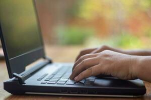 Male hands typing on laptop keyboard and surfing internet on desk, business concept and technology, internet network communication photo