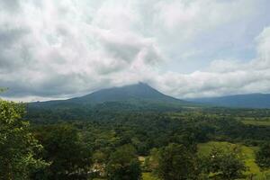 A lush garden in La Fortuna, Costa Rica with Arenal Volcano in the background photo