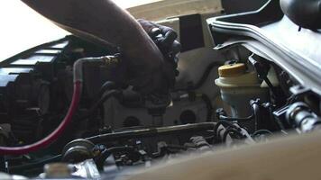 meester reparaties auto motor met hand- gereedschap in de reparatie winkel filmmateriaal. video