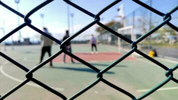 People Playing Outdoors on Iron Fence Basketball Court Footage. video