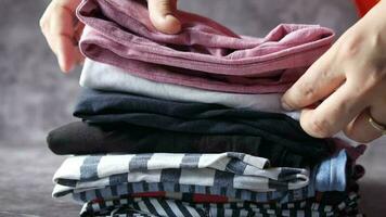 Woman hand counting stack of cloths on table video