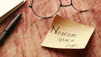 Never give up word on stick note on table video