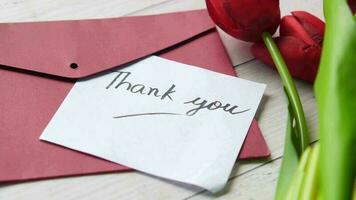 thank you message, envelope and tulip flower on table video