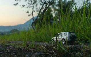 Concept for travel and adventure. A toy car with a mountain view in the early morning. photo