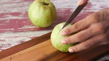 Young man cutting guava on a chopping board ,, video