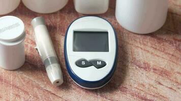 Close up of diabetic measurement tools and pills on color background video