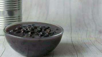 Grains black bean in a bowl on table , video