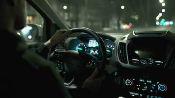 Man driving car through the streets of night city. View from the back seat of the car video