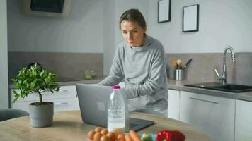 mujer mirando receta en línea mientras Cocinando video