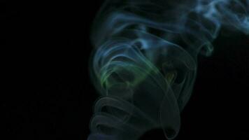 Abstract smoke rises up in beautiful swirls on black background. video