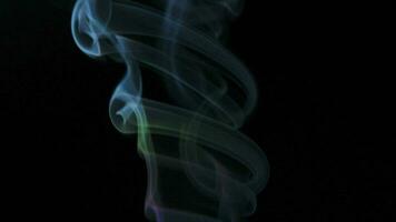 Abstract smoke rises up in beautiful swirls on black background. video