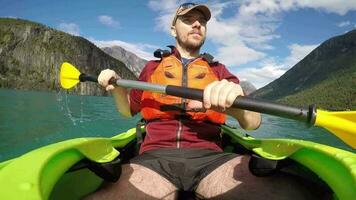 caucasiano desportista dentro a caiaque remar em glacial lago dentro corda Noruega video