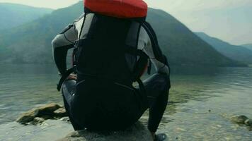 Kayaker Resting on the Rocky Lake Shore. Seating and Enjoying the View. video