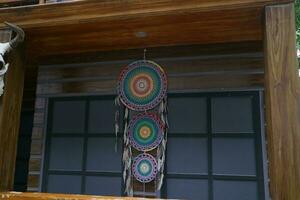 An object called a dream catcher hung on a wooden wall photo