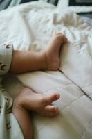 cute feet of a newborn baby on a white mattress photo