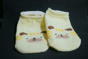 Cute baby socks yellow with a hamster face on them photo