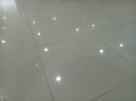 Photo of a gray tiled floor with white light shadows