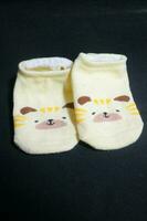 Cute baby socks yellow with a hamster face on them photo