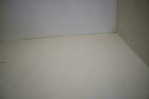 a corner of the wall of a room with white paint photo