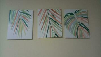 lona pintura representando palma hojas en un blanco pared foto