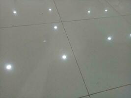 Photo of a gray tiled floor with white light shadows