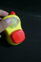 Cute yellow handy talky toy in hand photo