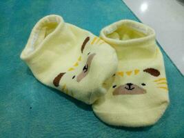 Cute baby socks in yellow and a guinea pig face photo