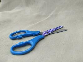 Medium sized paper scissors with light blue handles photo