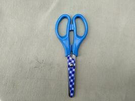 Medium sized paper scissors with light blue handles photo