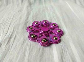 A toy called spinner is purple in color with a unique shape photo