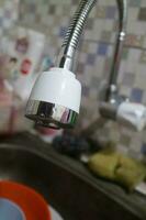 The head of a water faucet that is in the sink photo