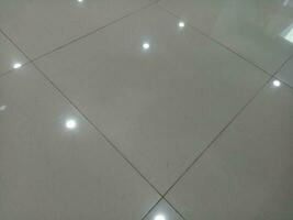 Photo of a gray tiled floor with white light shadows