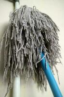 A mop head for cleaning floors, in worn white color photo