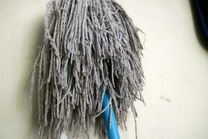 A mop head for cleaning floors, in worn white color photo