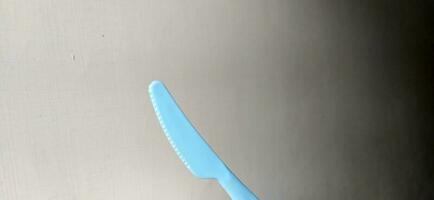 The knife for cutting steak is blue, made of plastic photo