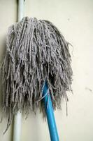 A mop head for cleaning floors, in worn white color photo