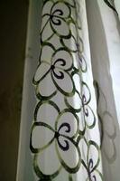 A curtain in front of the window with a transparent color and a flower pattern photo