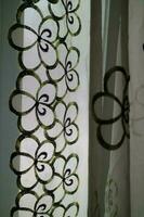 A curtain in front of the window with a transparent color and a flower pattern photo
