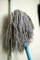 A mop head for cleaning floors, in worn white color photo