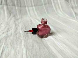 un rosado uña polaco con un único medio corazón conformado botella foto