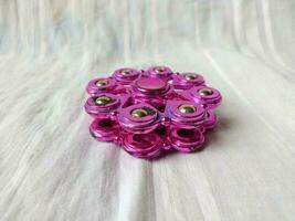 A toy called spinner is purple in color with a unique shape photo