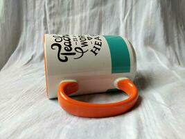 a glass mug for coffee or tea with white orange blue color photo