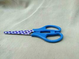 Medium sized paper scissors with light blue handles photo