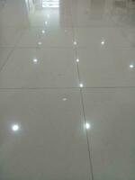 Photo of a gray tiled floor with white light shadows