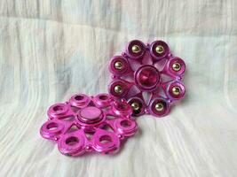 A toy called spinner is purple in color with a unique shape photo