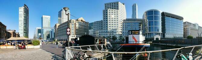 Low Angle Panoramic View of Canary Wharf Central London City with Tall Buildings, Road, People at Most Expensive Area of London City of England UK. The Footage Was Captured on 08-June-2023 photo