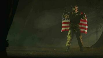 masculino americano soldado en lleno uniforme y con máquina pistola participación bandera video