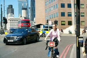 Beautiful Low Angle View of Central London and Road with Traffic and People. The Image Was Captured at Tower Bridge London England Great Britain on Warm Sunny Day of 04-June-2023 photo