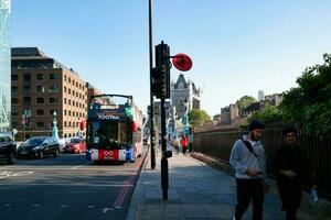 Beautiful Low Angle View of Central London and Road with Traffic and People. The Image Was Captured at Tower Bridge London England Great Britain on Warm Sunny Day of 04-June-2023 photo