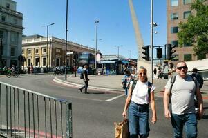 Beautiful Low Angle View of Central London and Road with Traffic and People. The Image Was Captured at Tower Bridge London England Great Britain on Warm Sunny Day of 04-June-2023 photo